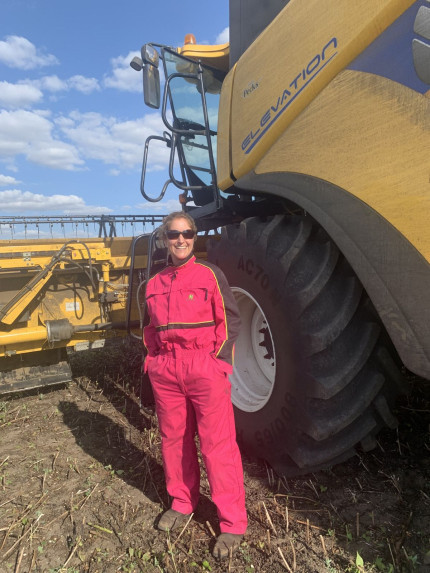 Farmer Suzi in field next to combine